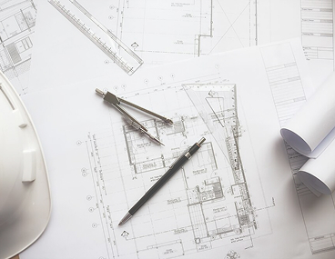 Строительные чертежи с каской, циркулем и карандашом